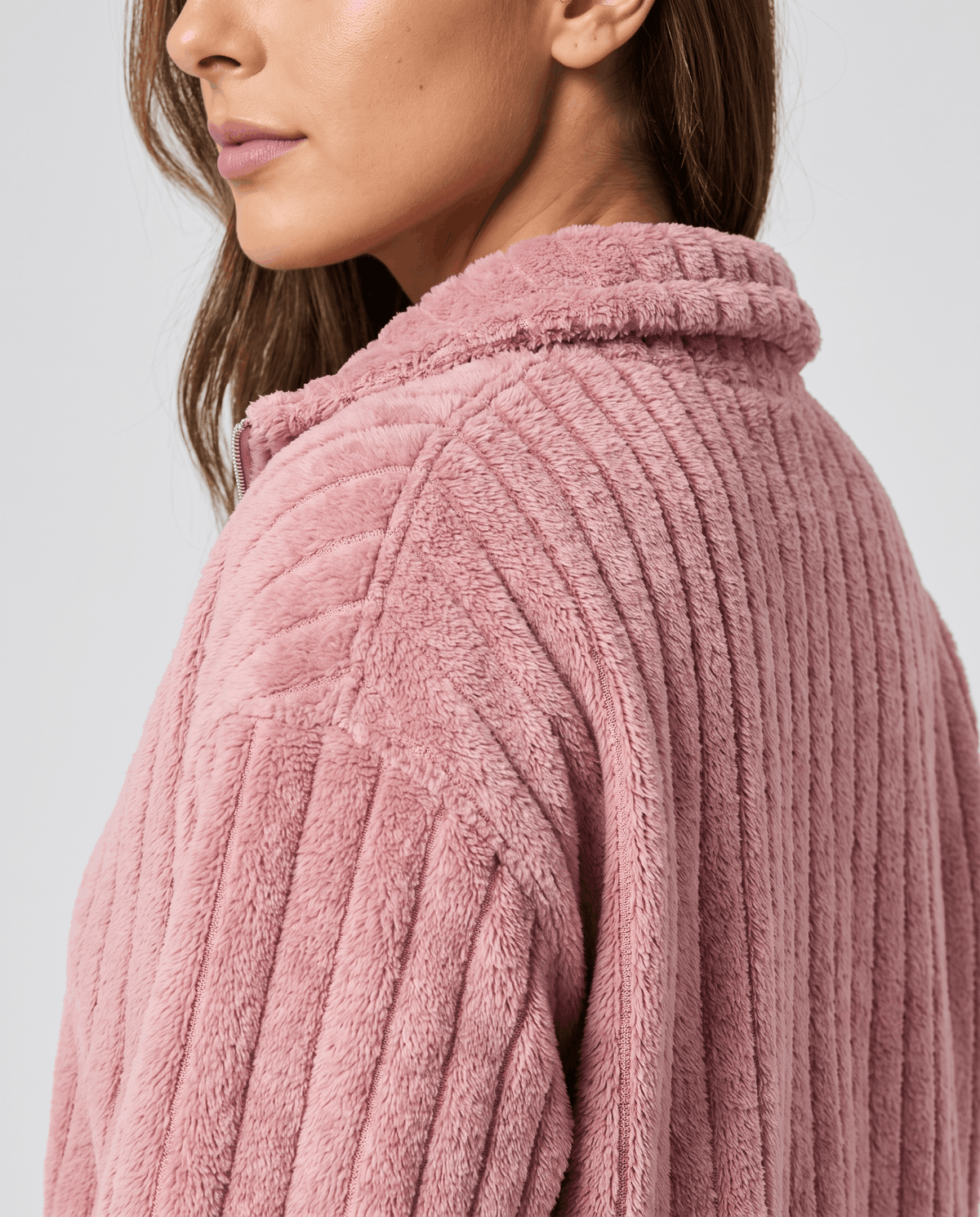 Close-up of stand collar and fuzzy vertical ribs on a dusty pink pullover
