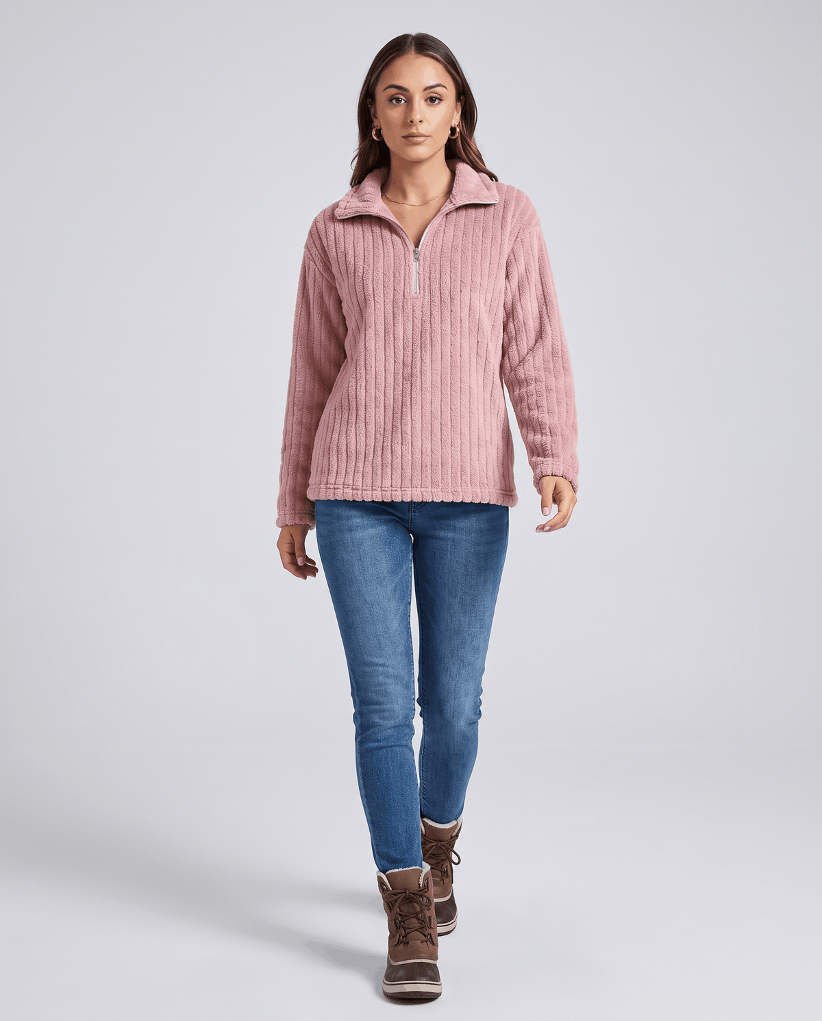 Full-length view of dusty pink pullover with medium wash jeans and ankle boots