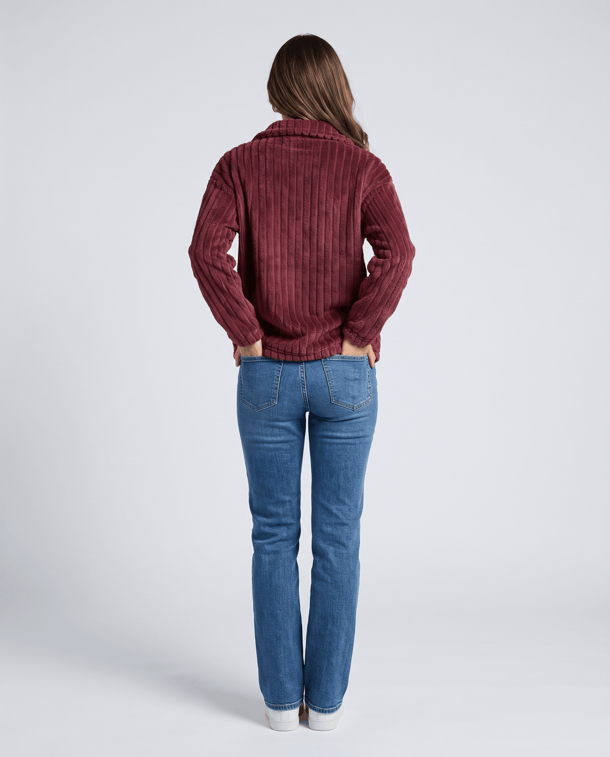 Back view of burgundy red pullover with vertical ribs and light jeans