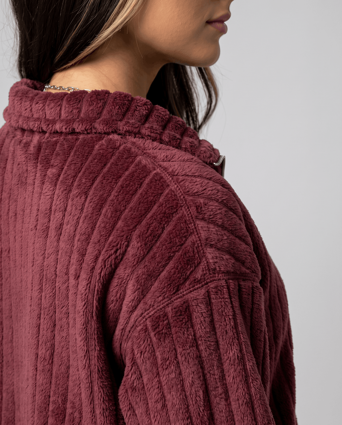 Close-up of deep red plush ribs and stand collar at the shoulder