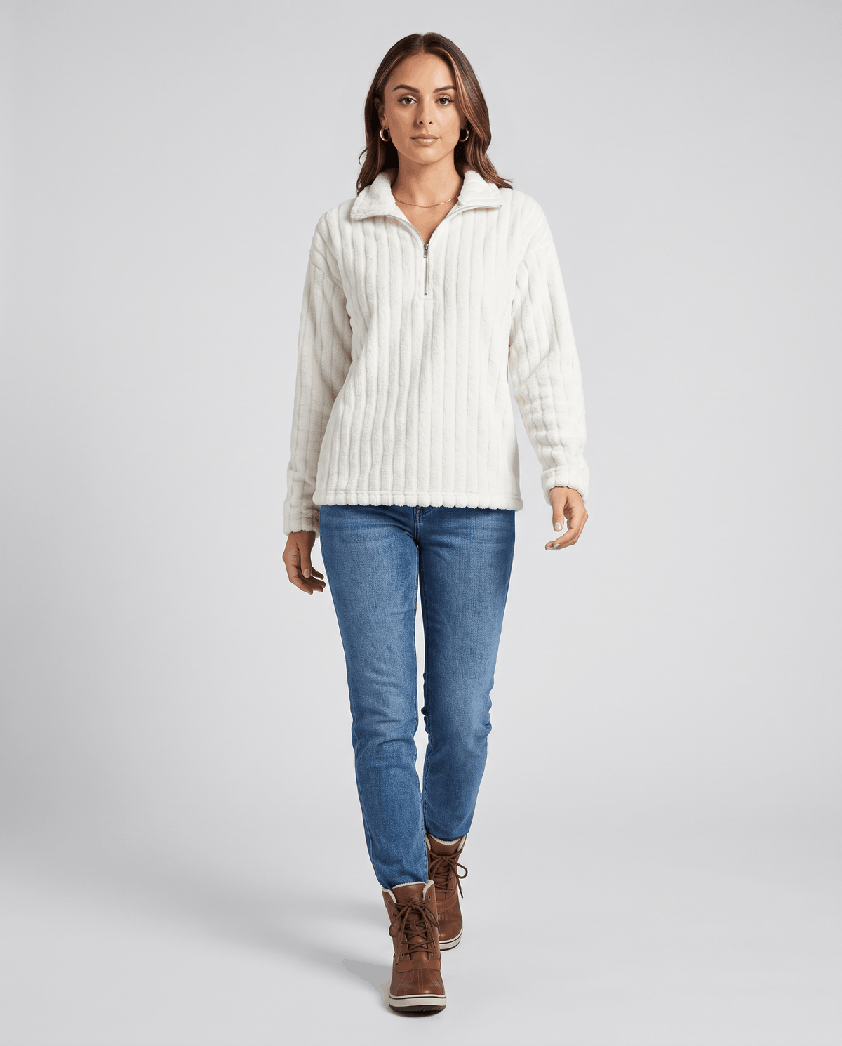 Full-length view of white ribbed pullover with light jeans and brown boots
