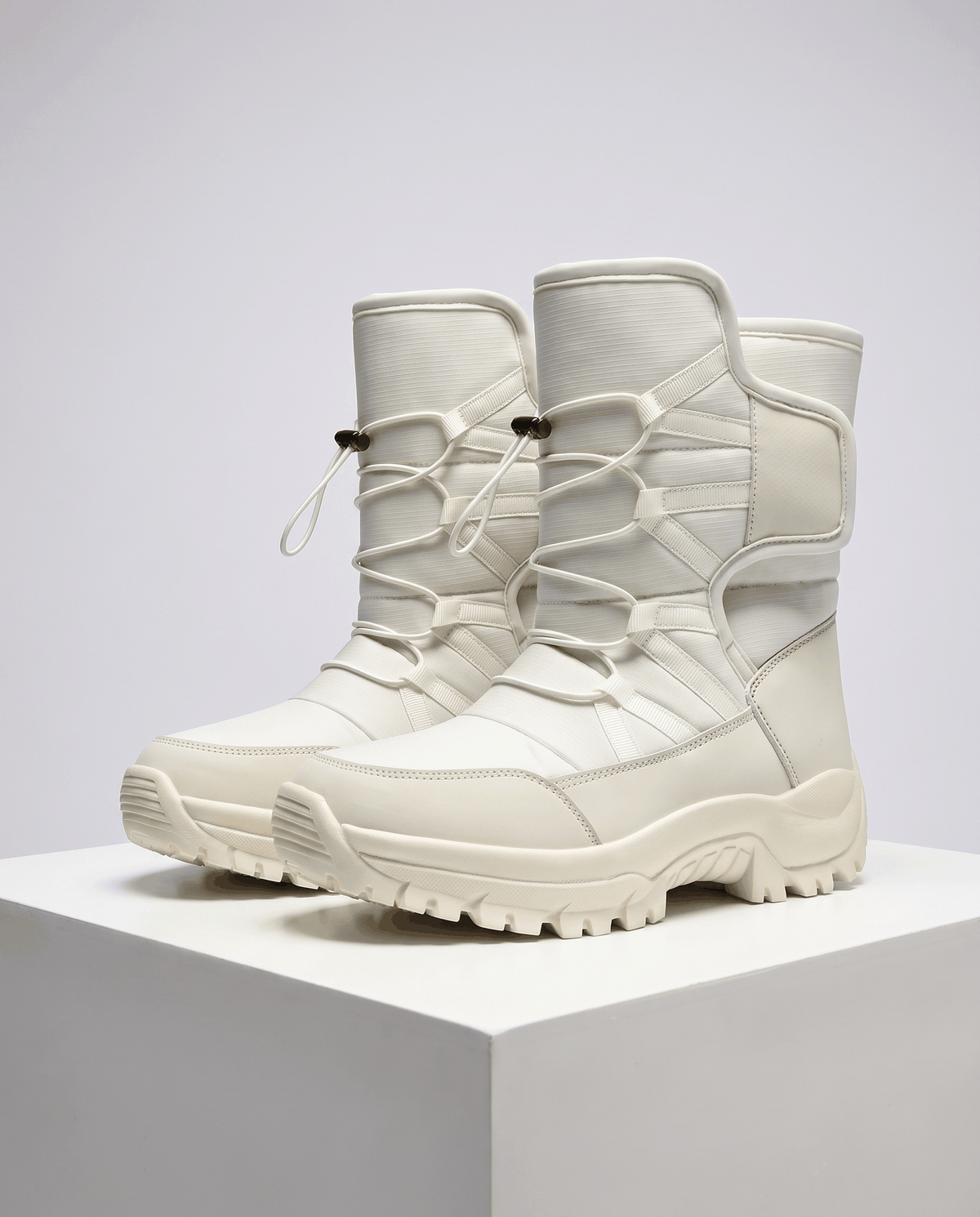Beige quilted boots with drawstring tops and chunky off-white lug soles on a white plinth