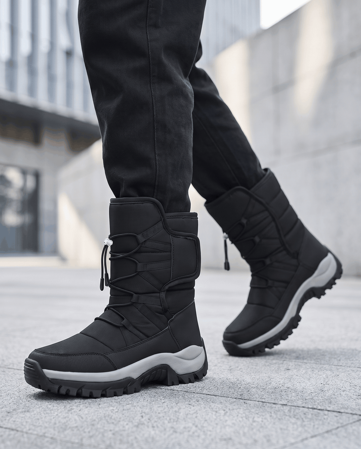 Black quilted boots with chunky soles worn with dark jeans on a city sidewalk