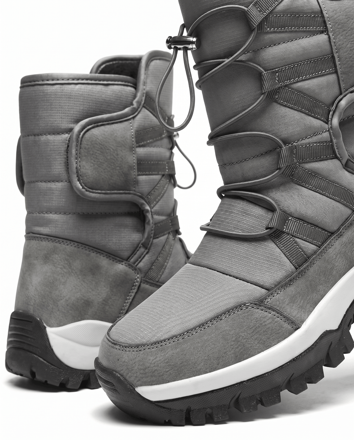 Close view of two gray quilted boots showing cord tops and light sole stripes