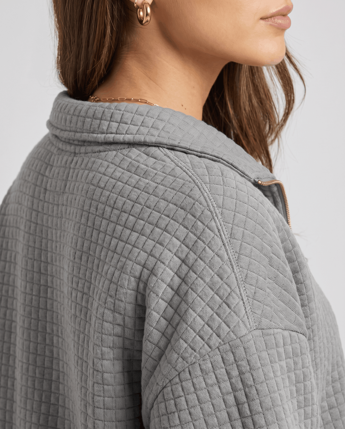 Close-up of gray square quilting and stand collar at the shoulder