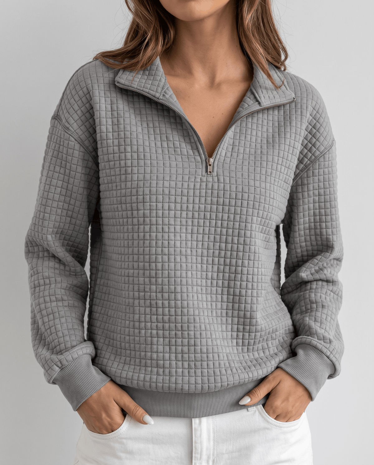 Cropped front view of heather gray quilted pullover with hands in pockets