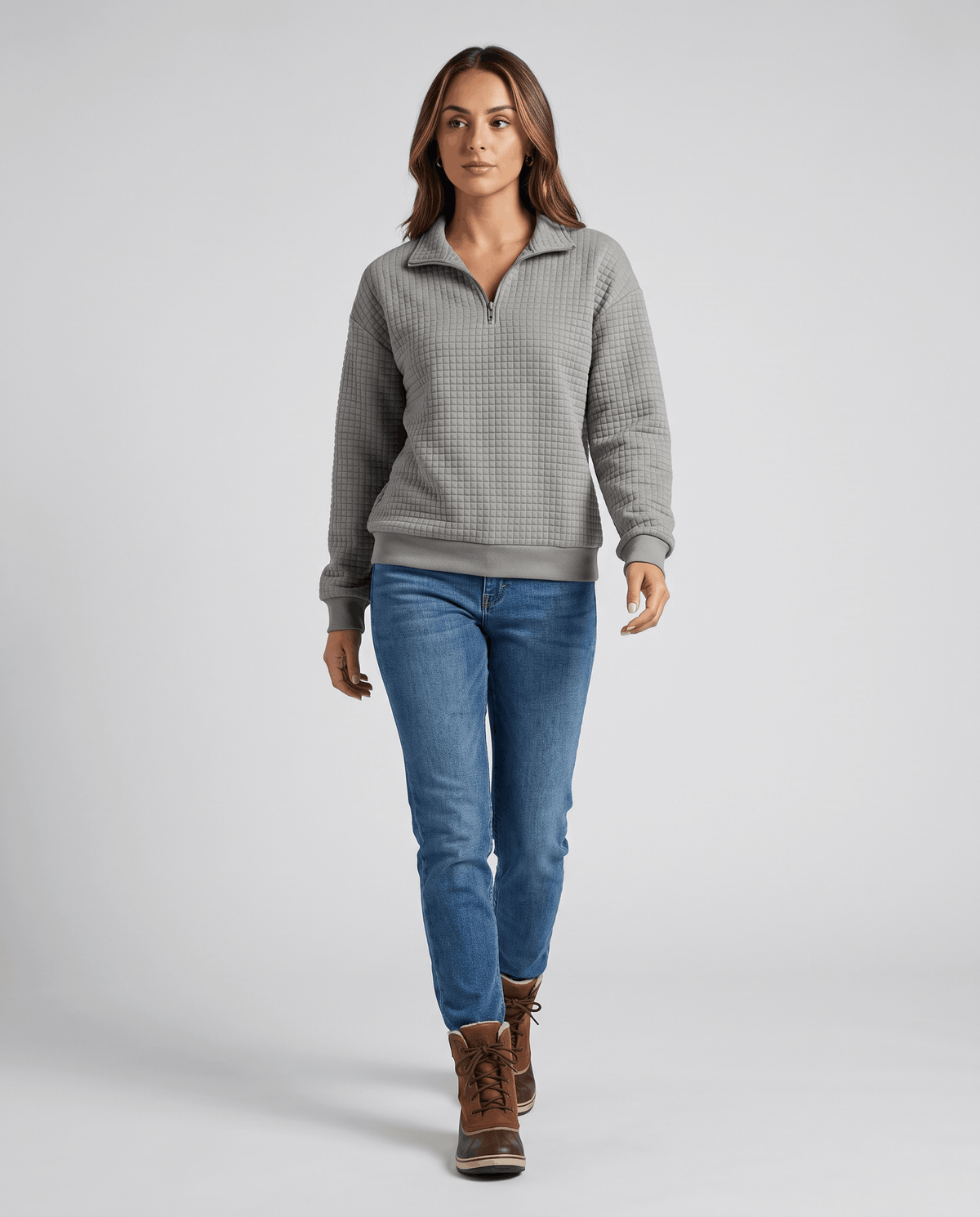 Full-length view of gray quilted pullover with jeans and brown ankle boots
