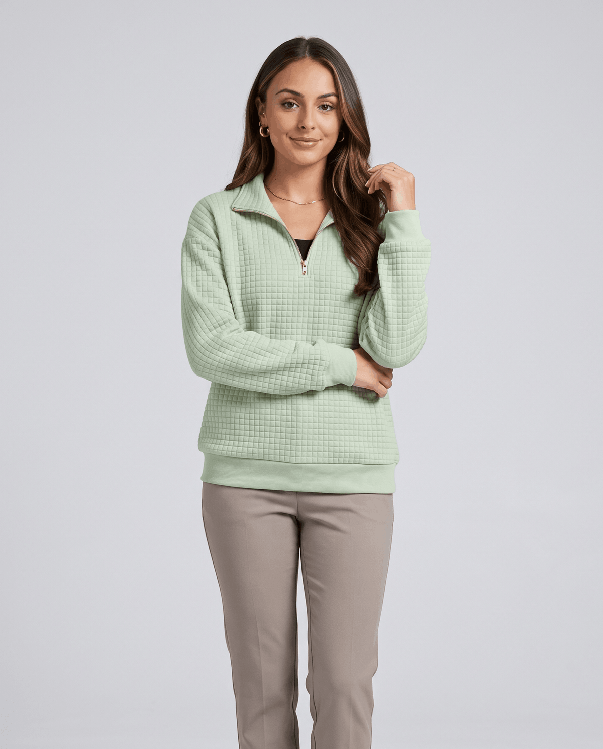 Front view of mint green quilted pullover styled with khaki pants