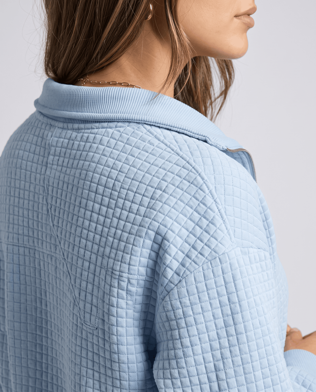 Shoulder detail showing grid quilting and collar on a sky blue knit
