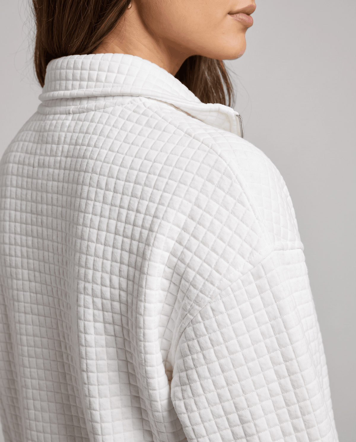 Close-up of white grid quilting and stand collar at the shoulder