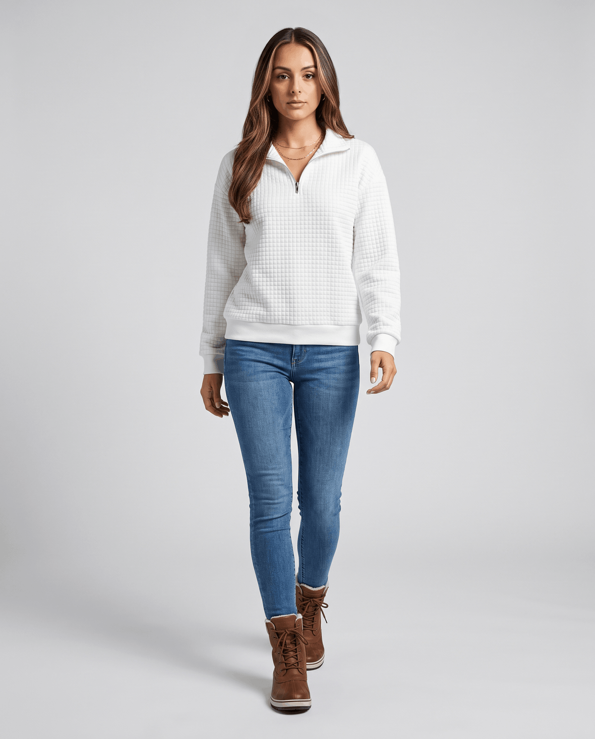 Full-length view of white pullover with light jeans and brown ankle boots