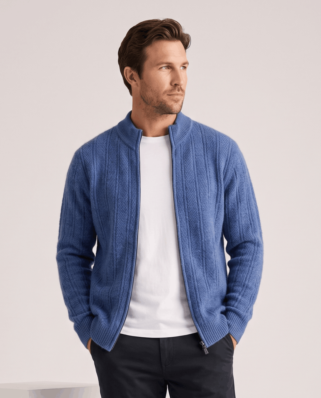 Blue cardigan zipped open over a white tee with dark trousers