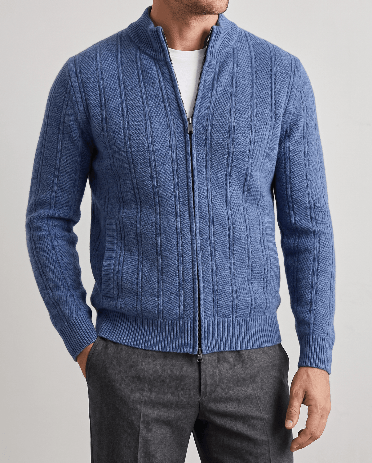 Front view of the blue ribbed knit cardigan zipped up with gray trousers