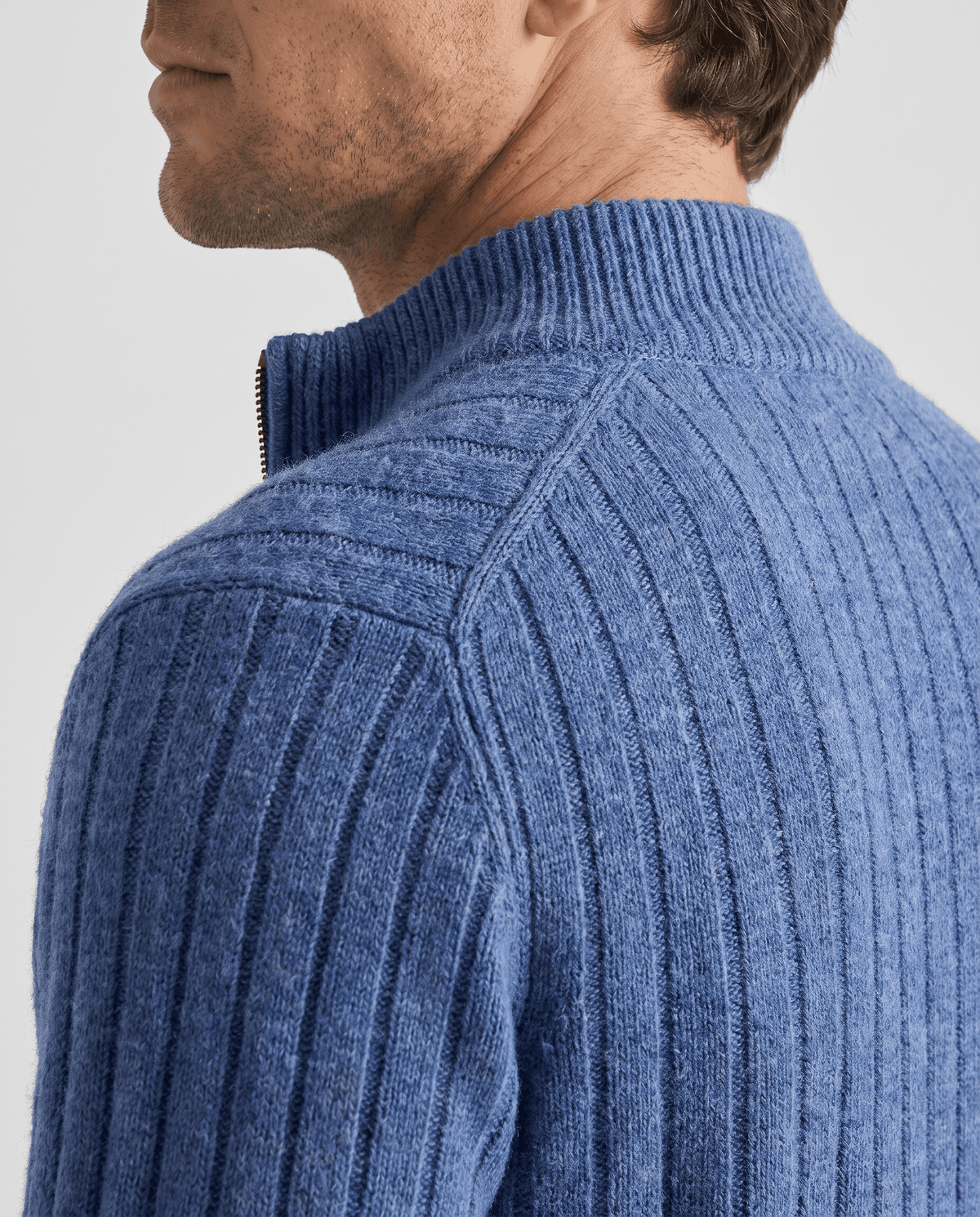 Shoulder detail of the blue cardigan showing its ribbed knit texture
