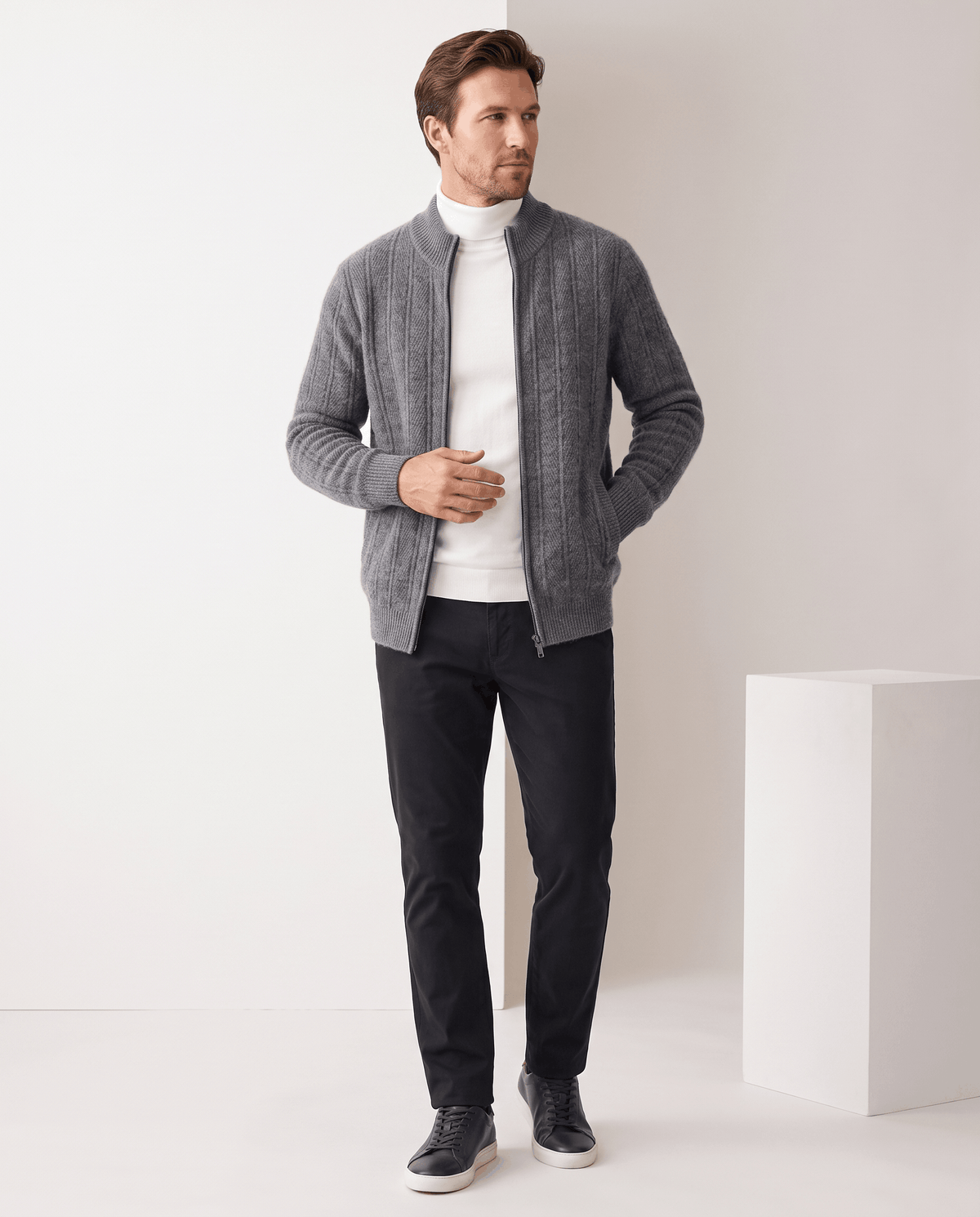 Full-length view of the gray cardigan over a white turtleneck with black trousers