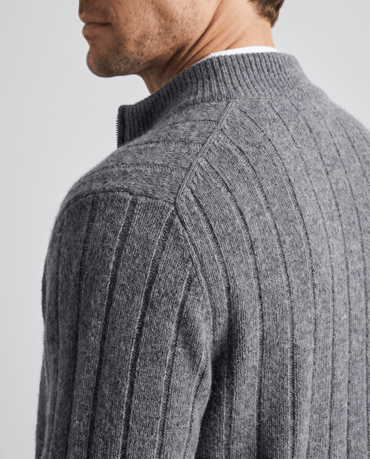 Shoulder detail of the gray cardigan showing the thick vertical rib knit