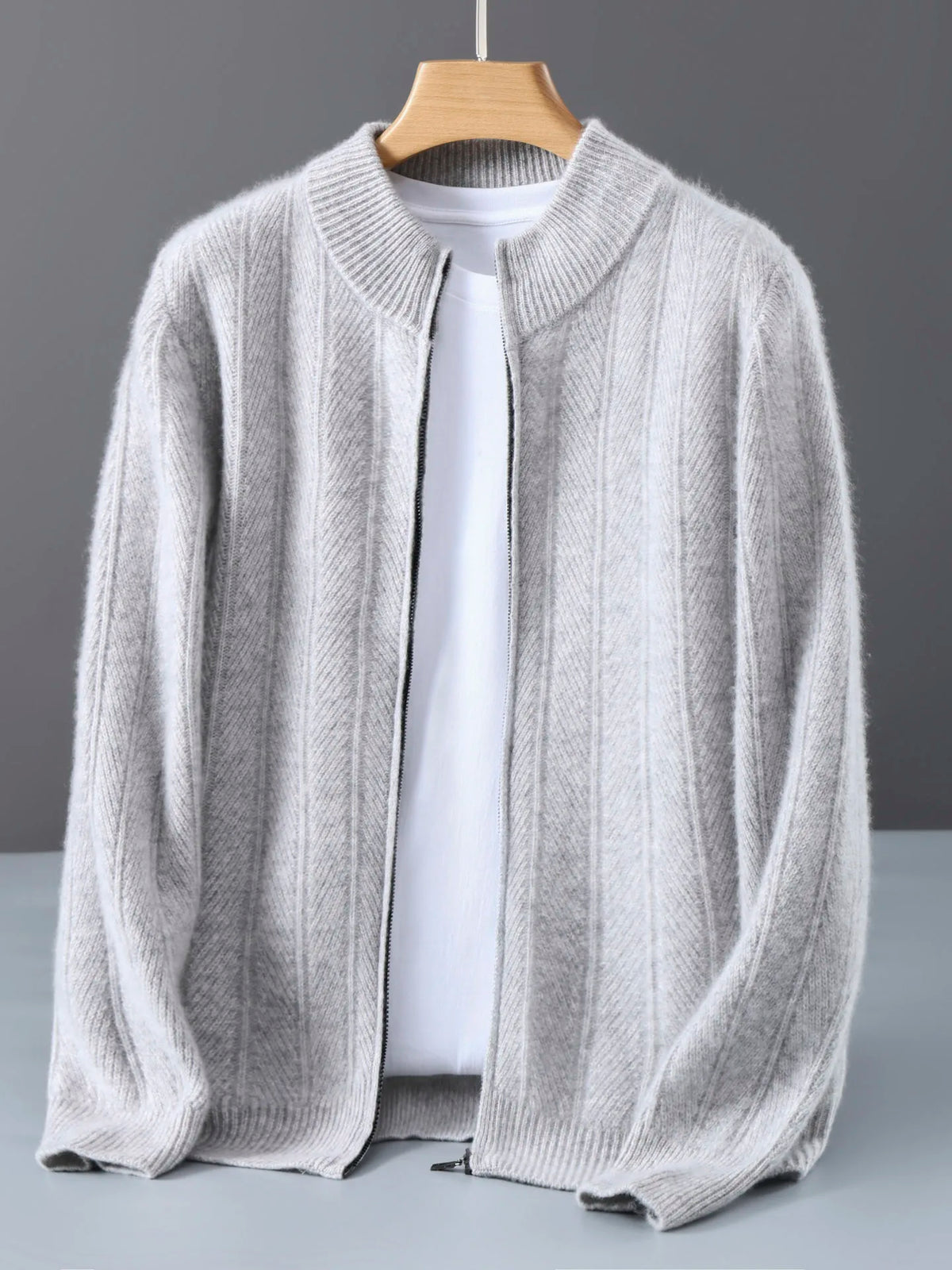 Light gray zip cardigan on a wooden hanger, open over a white tee
