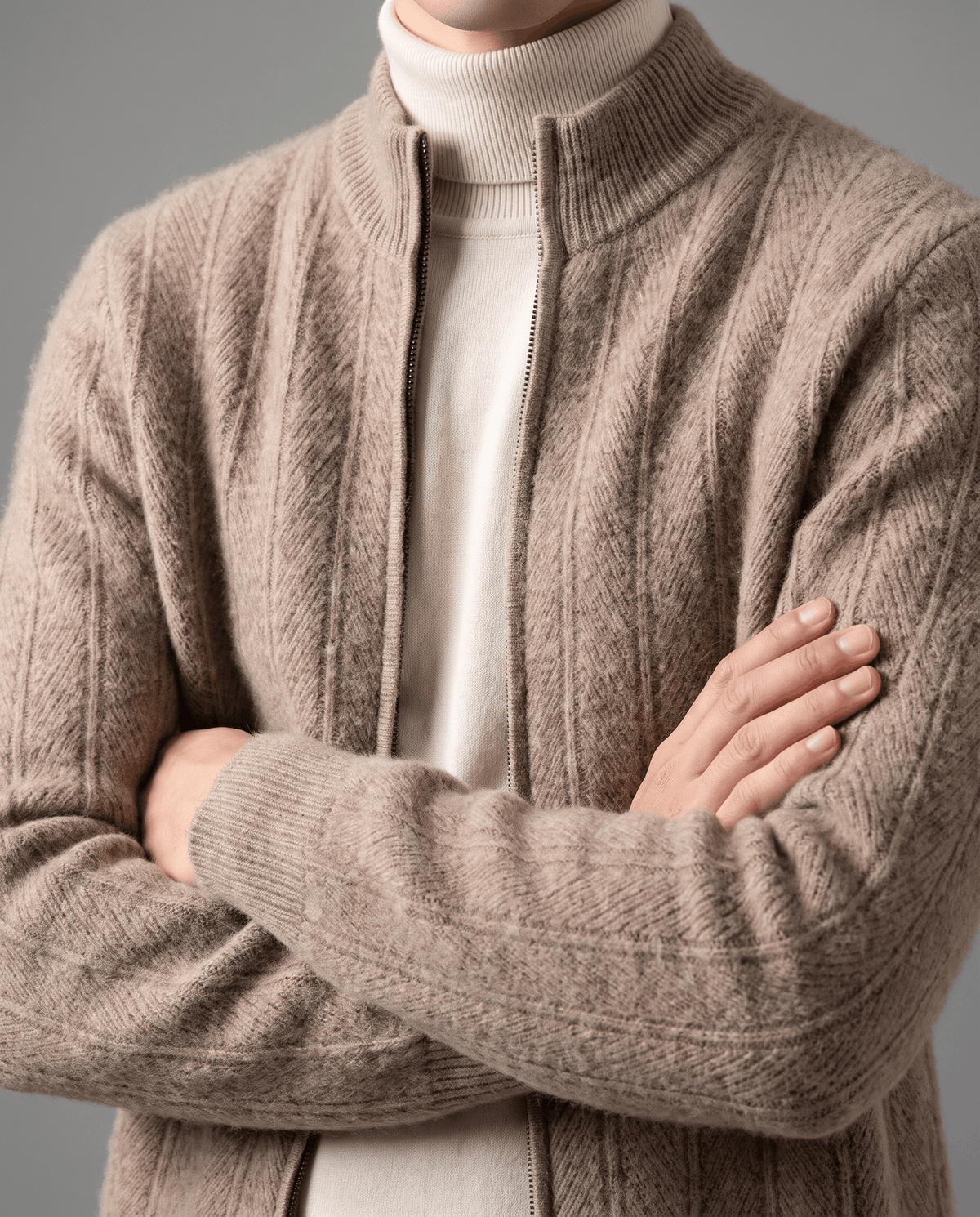 Taupe ribbed cardigan worn open over a cream turtleneck with arms crossed