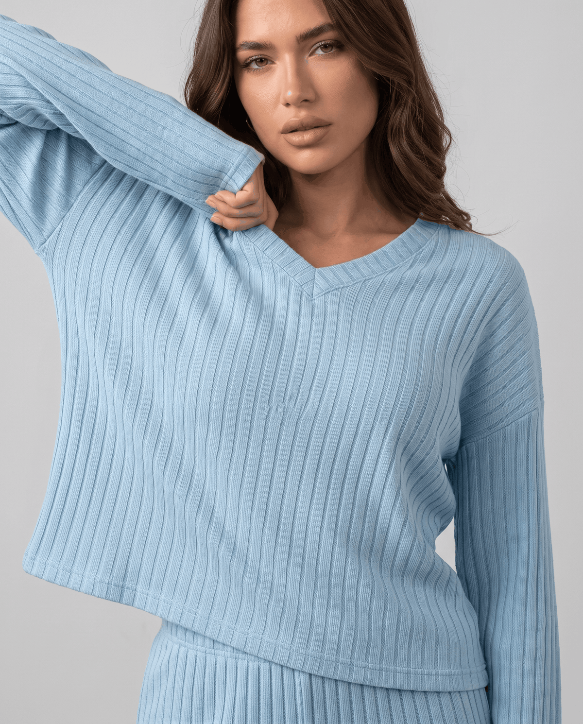 Close-up of the light blue ribbed knit top with a raised sleeve