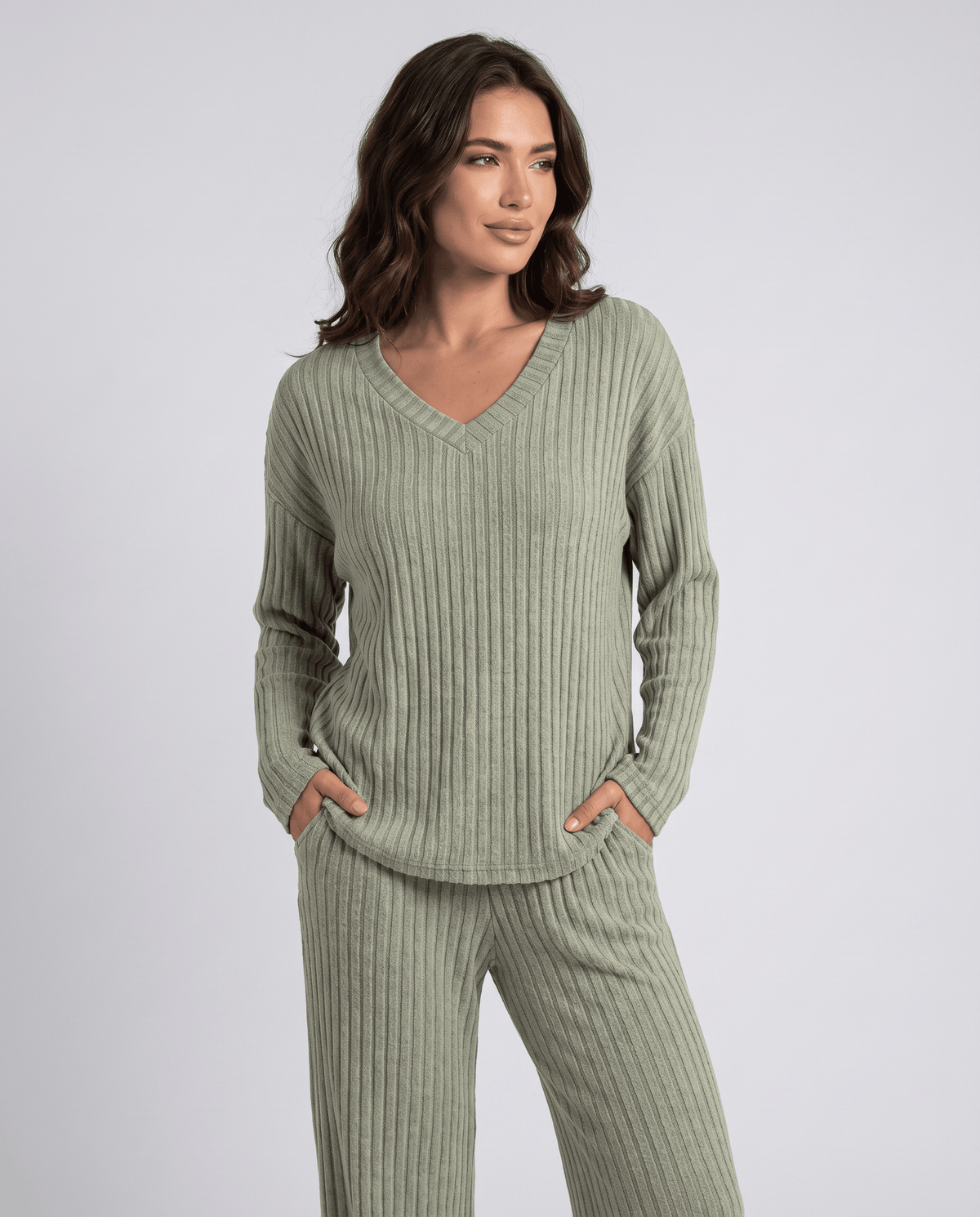 Sage green ribbed knit V-neck top with hands in pockets, close front view