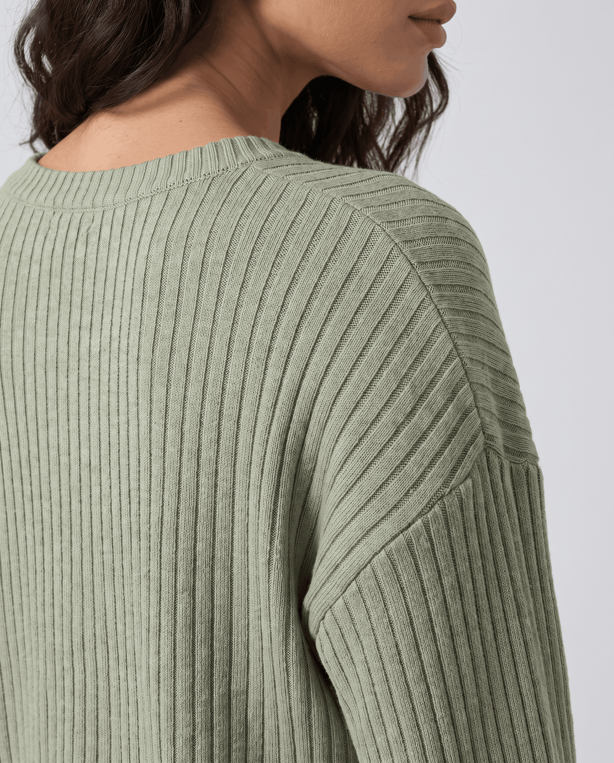 Close-up of the sage green ribbed knit texture on the sleeve
