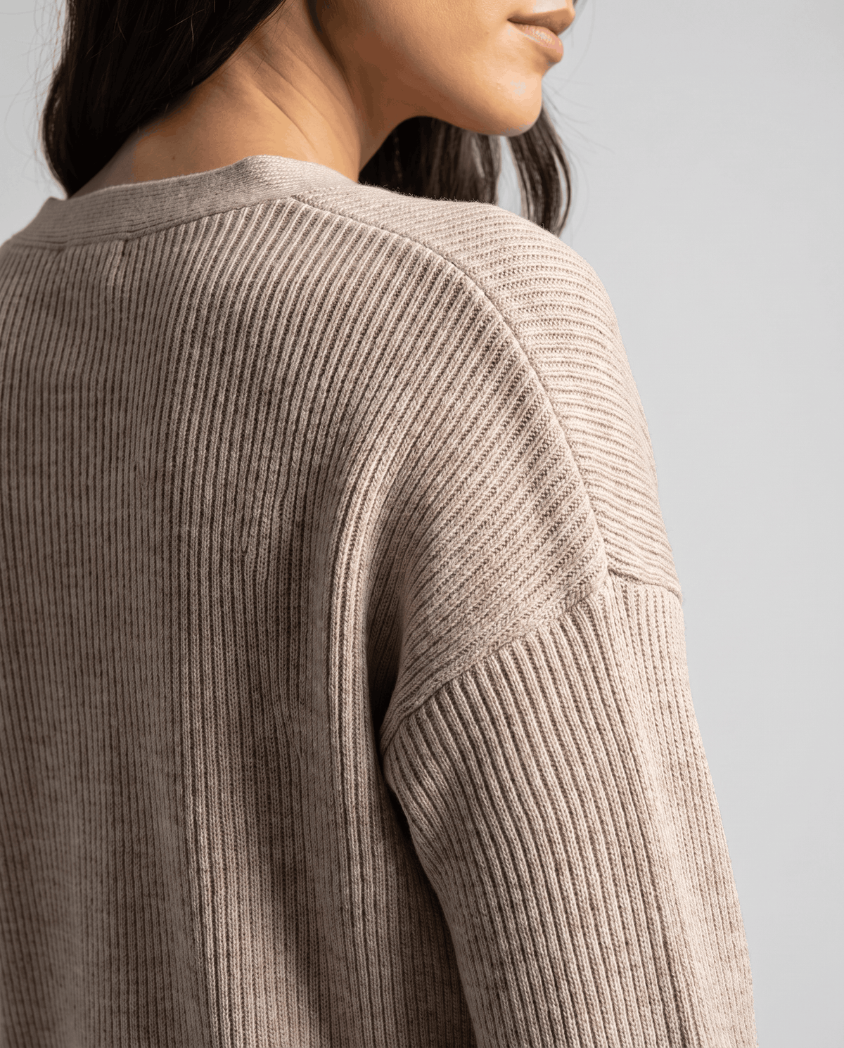 Close-up of the ribbed back and shoulder on the beige knit cardigan