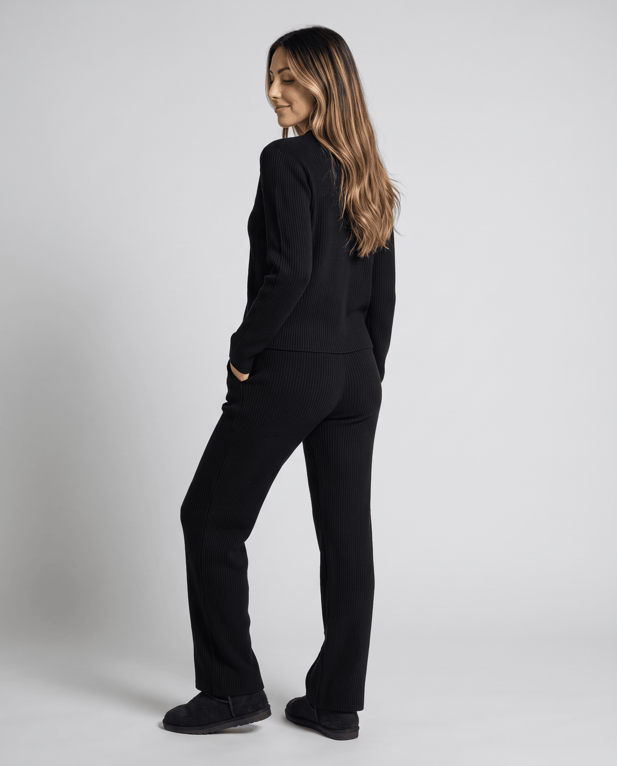 Black ribbed knit loungewear set, back view with hands in pockets
