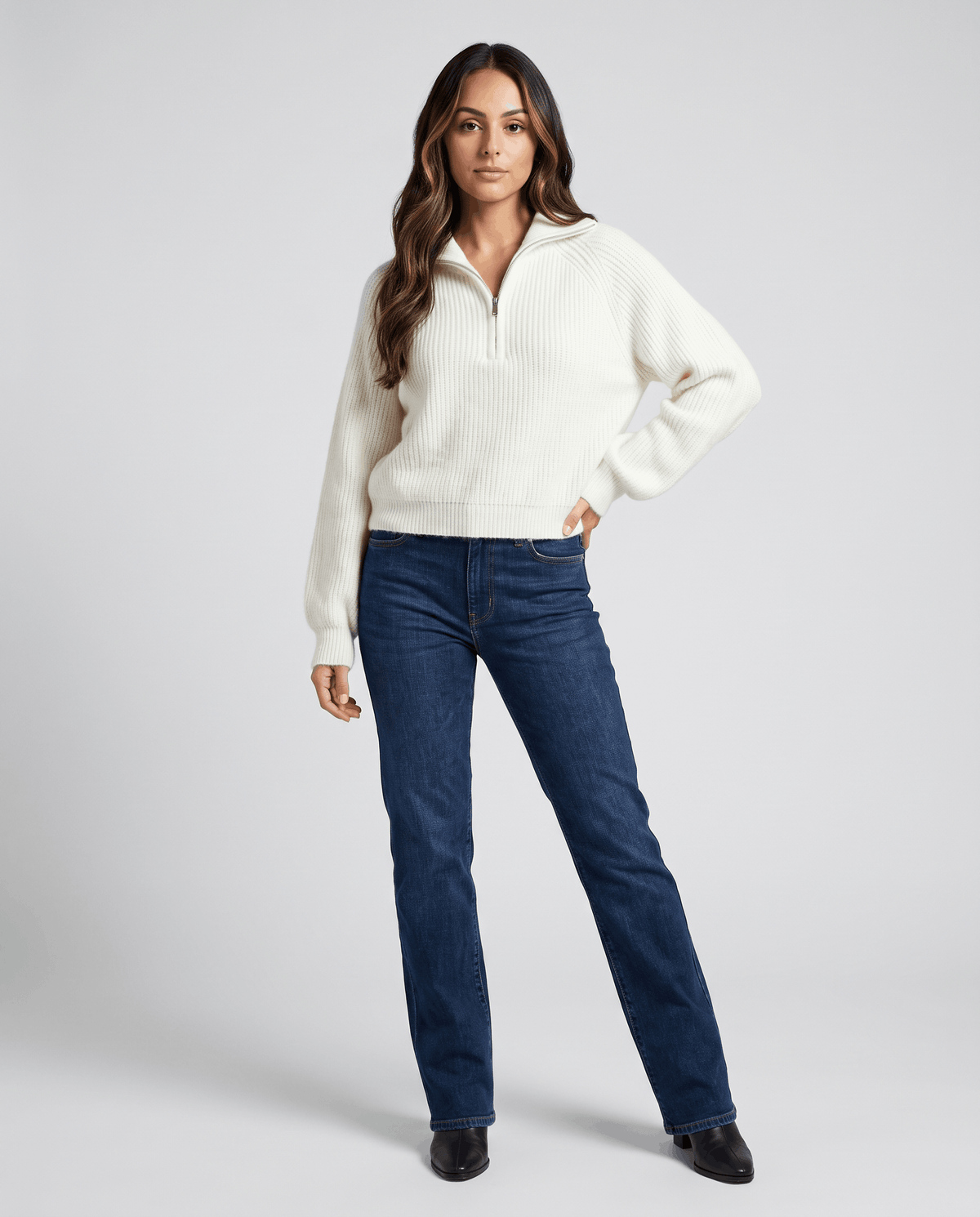 Full-length view of cream sweater with dark jeans and black boots
