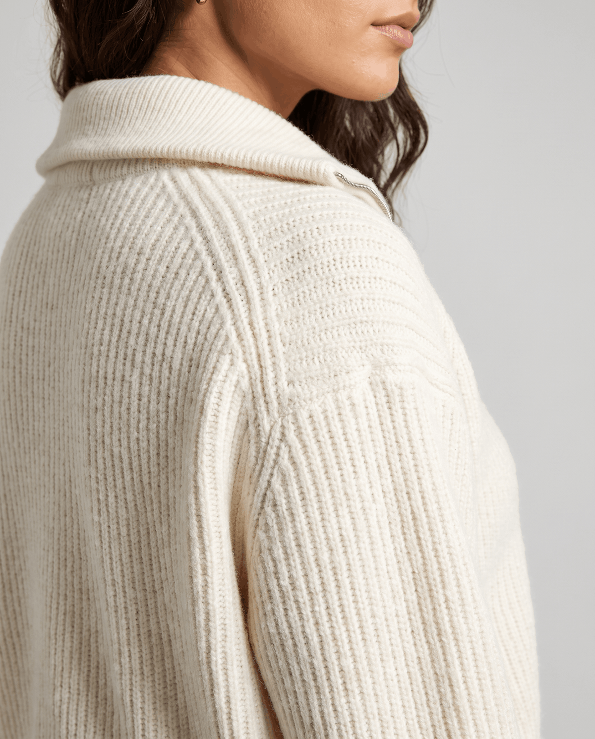 Rear shoulder detail of cream sweater showing the ribbed raglan seam