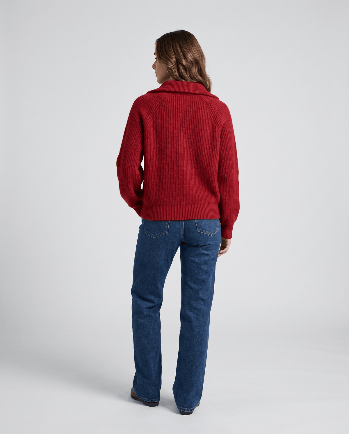Back view of red sweater with straight-leg blue jeans
