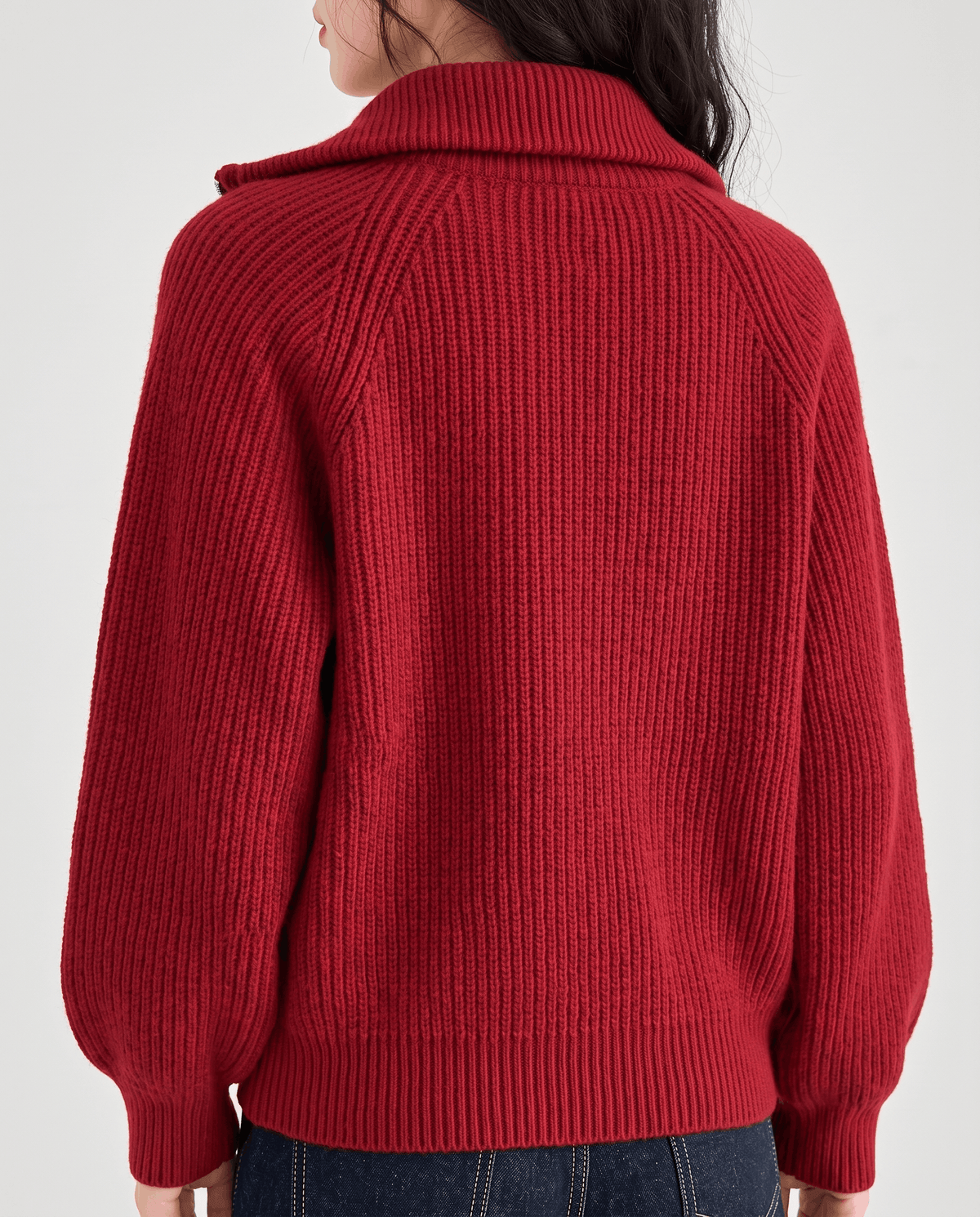 Back close-up of red sweater showing the ribbed knit and raglan seams
