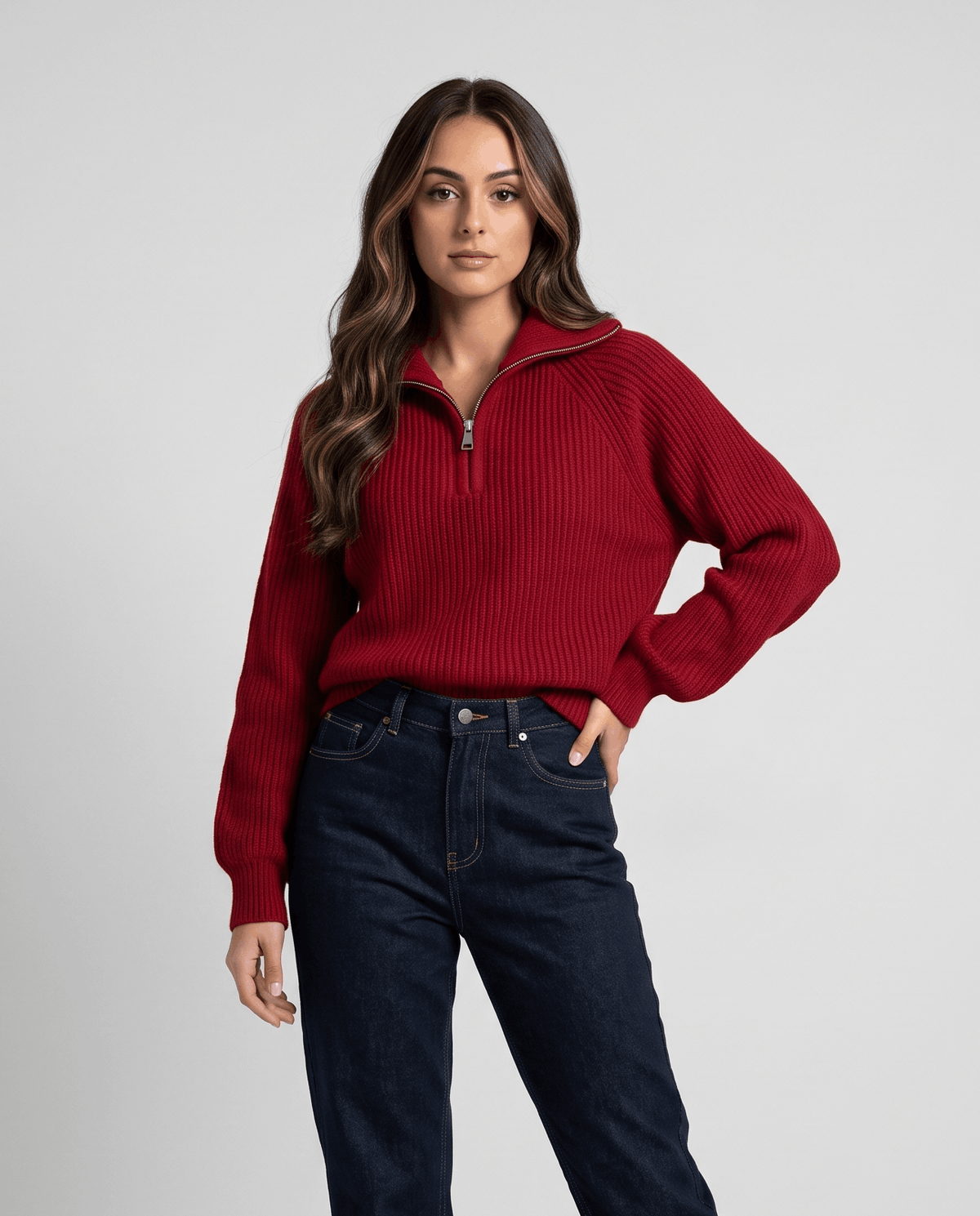 Woman in red ribbed knit quarter-zip sweater with dark jeans