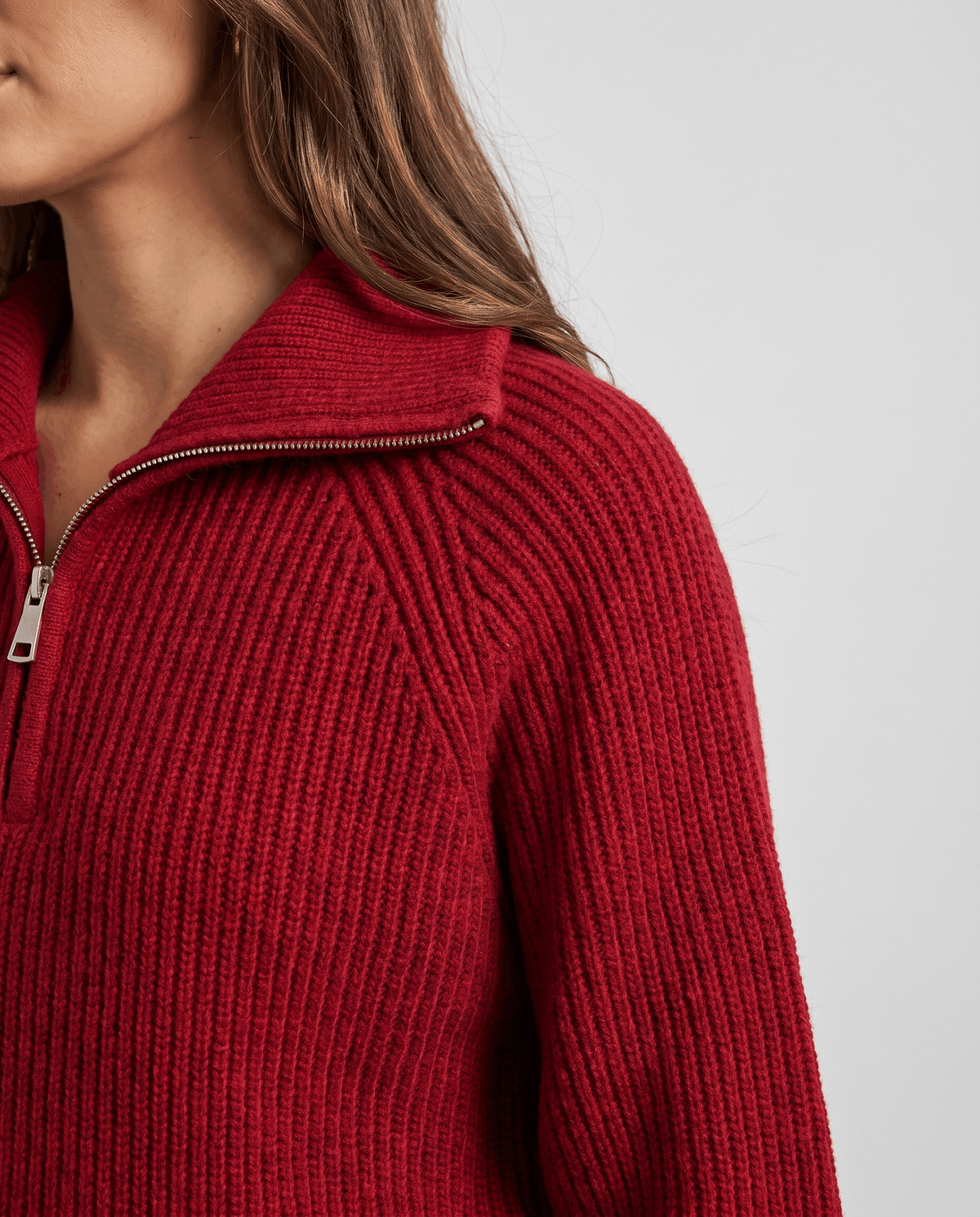 Side shoulder detail of red sweater with ribbed knit and collar