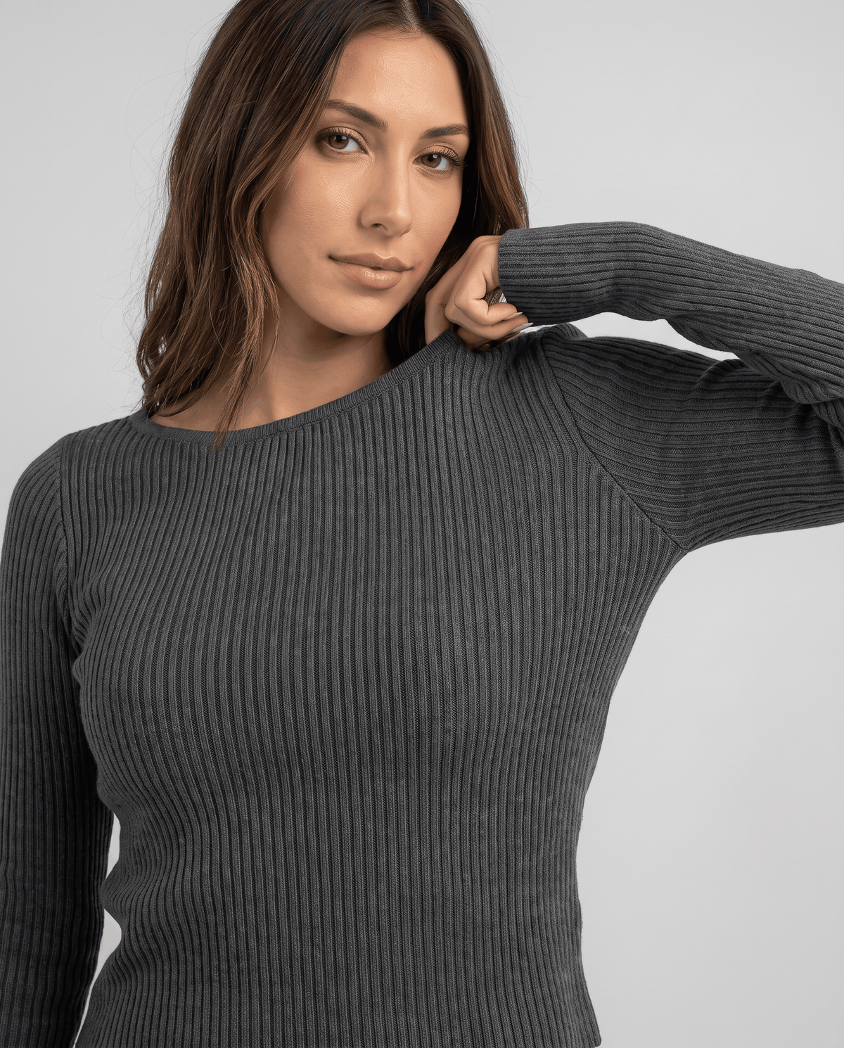 Dark gray ribbed crew-neck top close-up with the model's hand resting at the neck