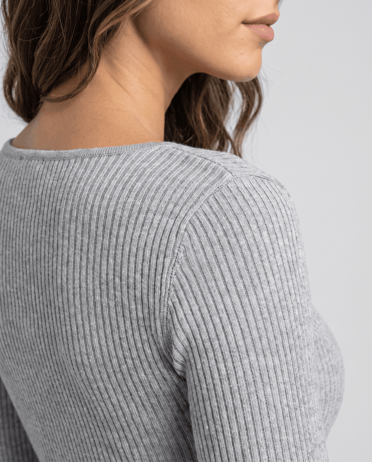 Close-up of gray ribbed knit texture on the sleeve and side of the top