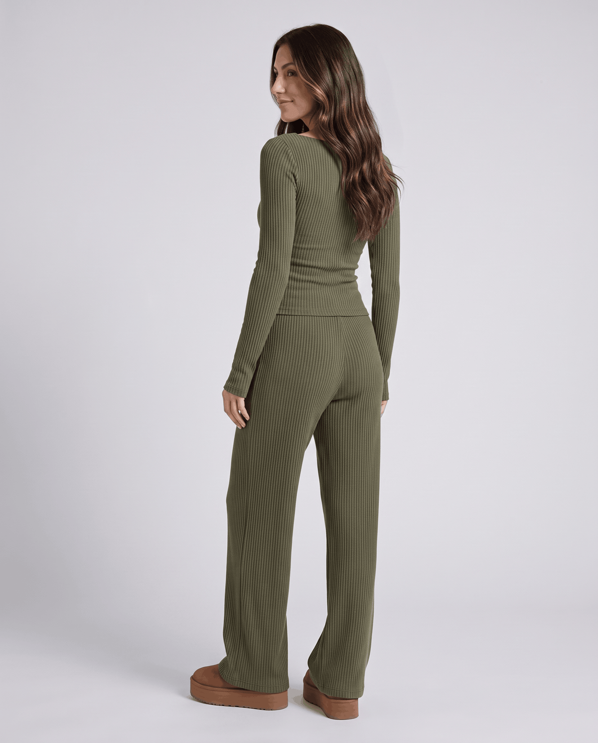 Back three-quarter view of the green ribbed top and wide-leg pants with brown shoes