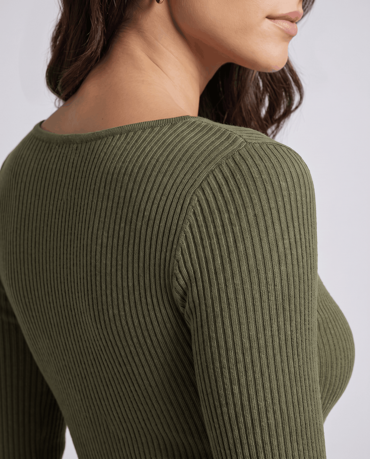 Close-up of green ribbed knit sleeve and shoulder showing the vertical ribbing