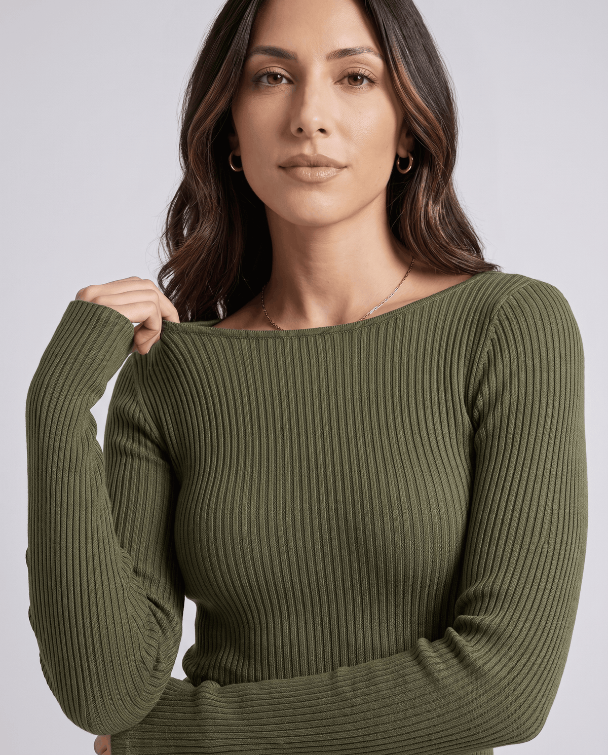 Green crew-neck top close-up showing the neckline and ribbed long sleeves