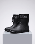 Pair of black rubber boots with drawstring collars standing on a grey block