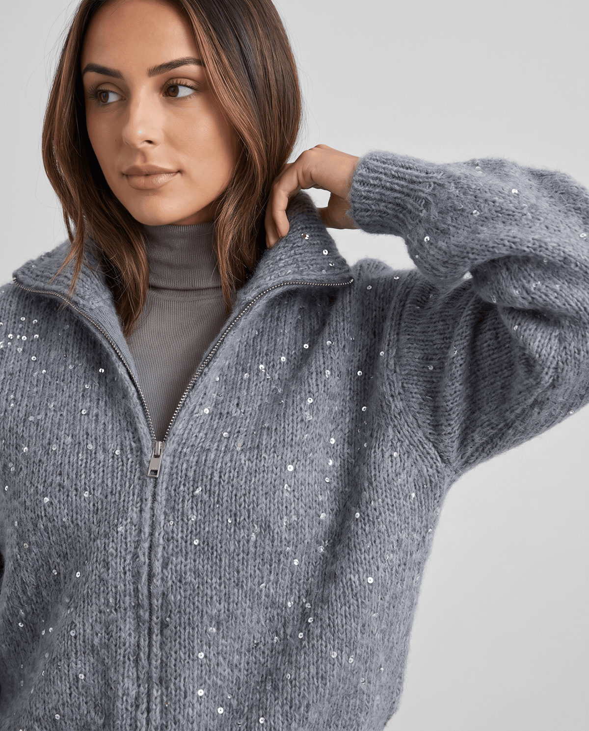 Close-up of the gray knit cardigan collar and zip over a gray turtleneck