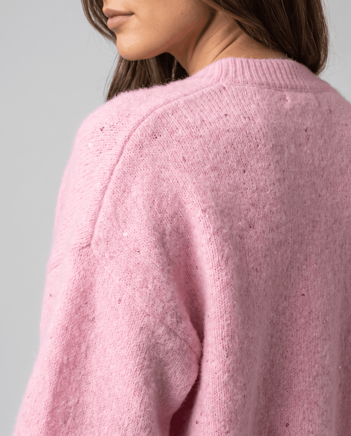Back shoulder detail of the pink cardigan showing the soft knit and tiny sequins