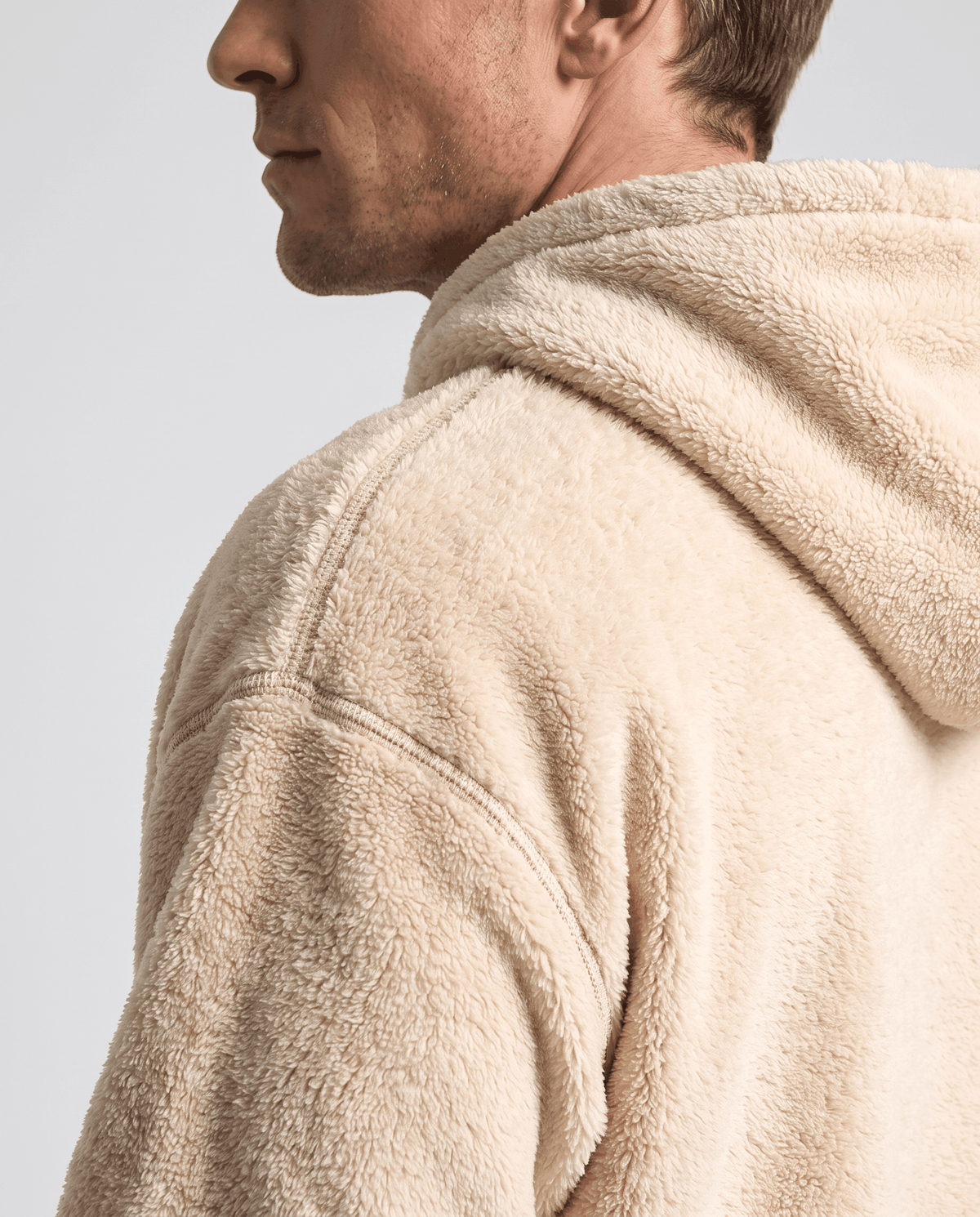 Shoulder and hood detail of the beige hoodie showing its fuzzy pile