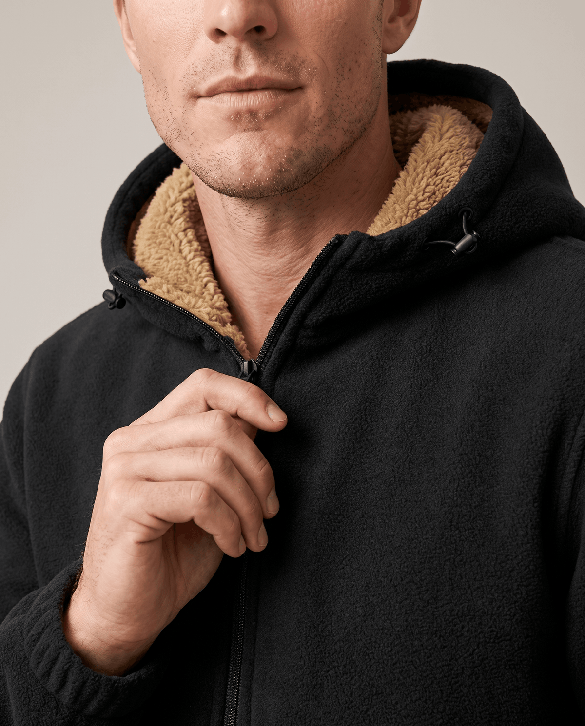 Close-up of the zip and sherpa-lined hood on the black fleece hoodie