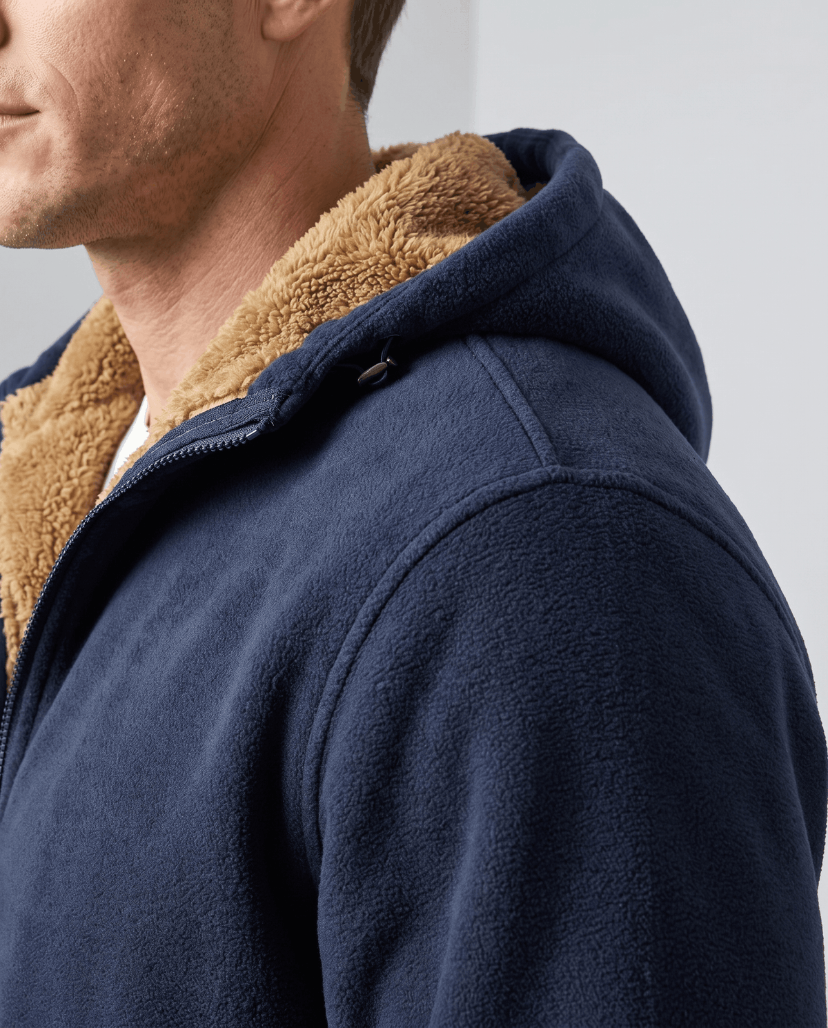 Side view of the navy hoodie's hood and shoulder showing the sherpa lining