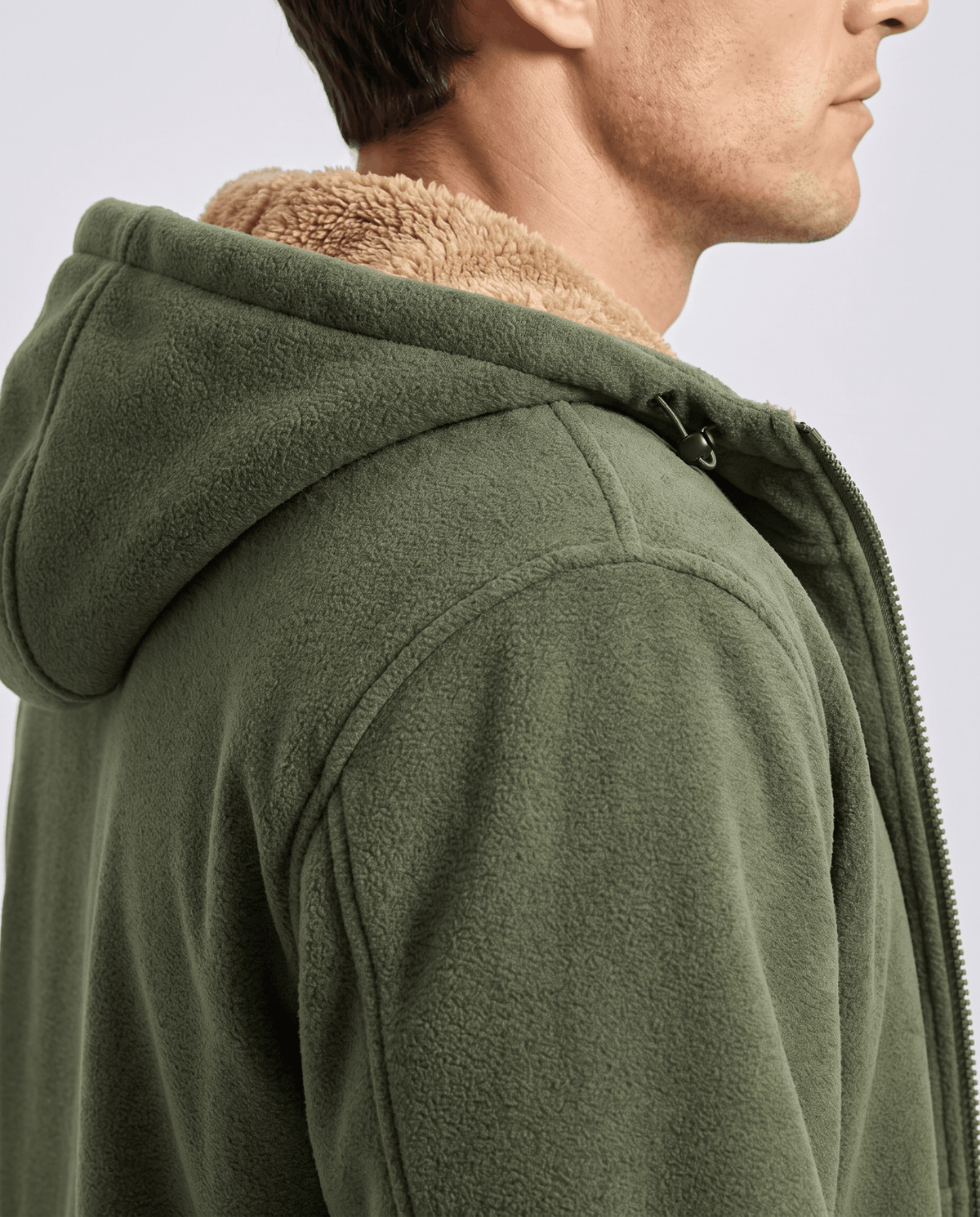 Side view of the green hoodie's hood showing the tan sherpa lining
