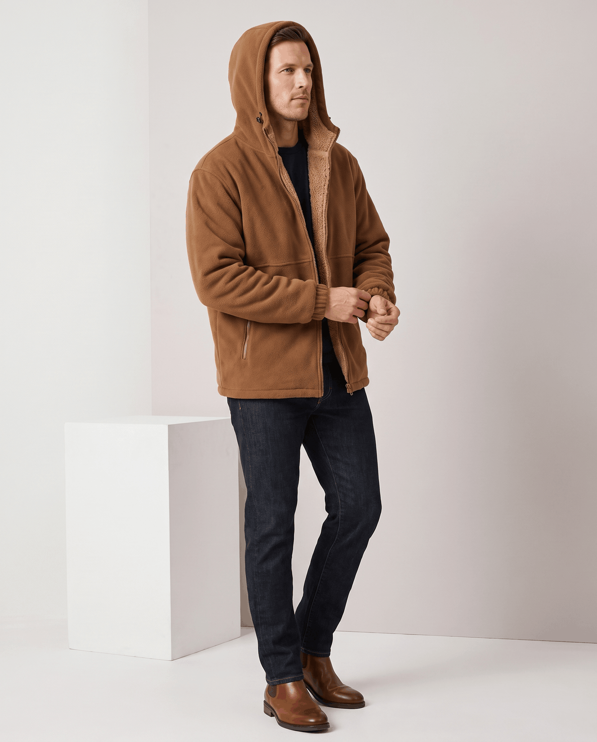 Full-length view of the khaki hoodie with dark jeans and brown leather boots