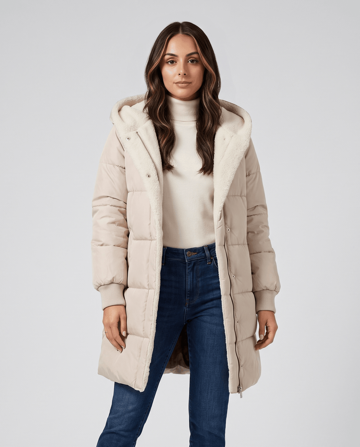 Woman in beige sherpa-lined puffer coat worn open over a cream top
