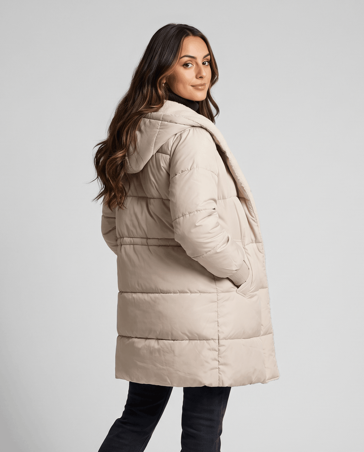 Side view of beige coat with hands in the side pockets