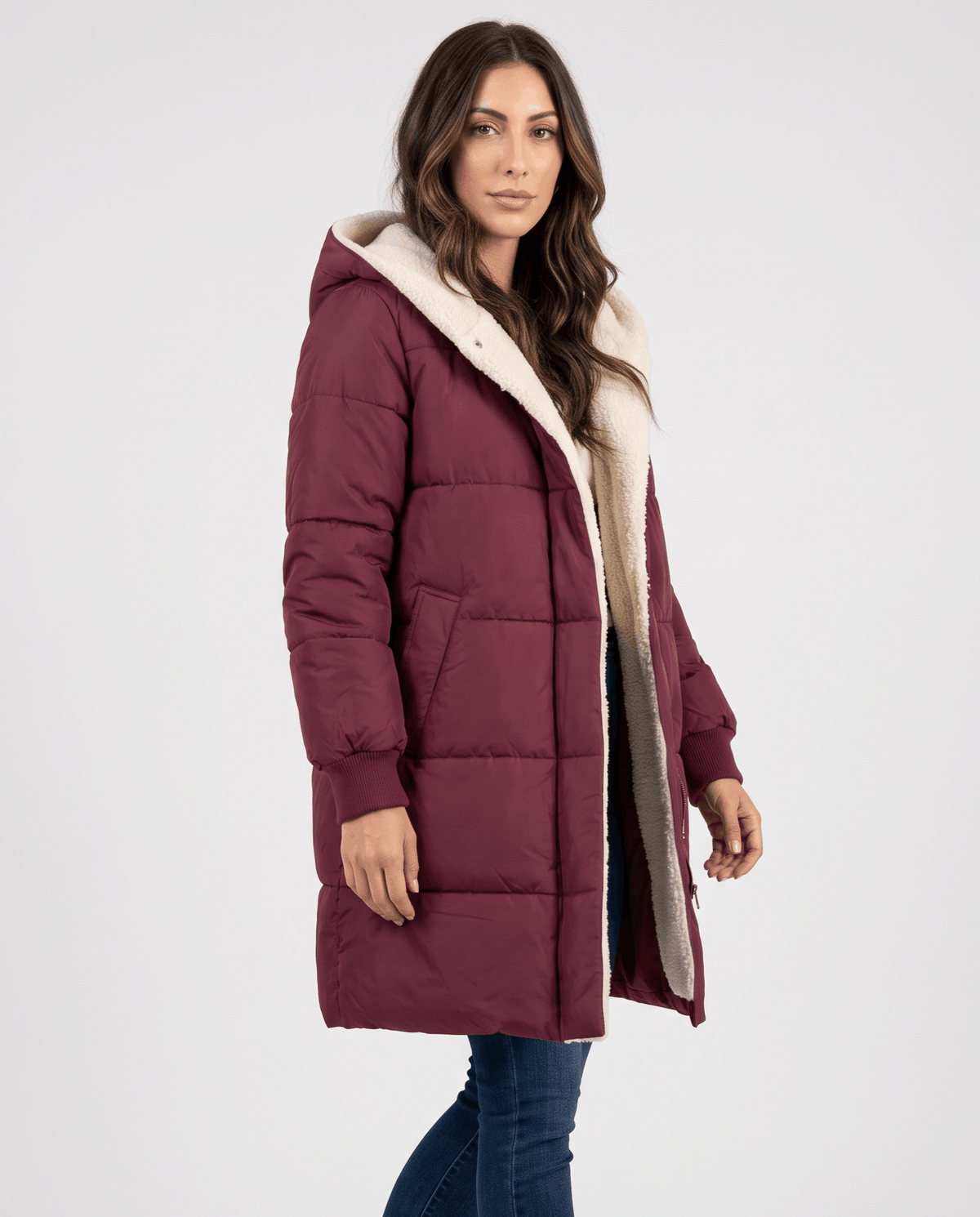 Woman in wine red sherpa-lined puffer coat worn open