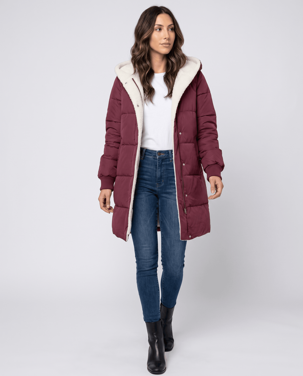 Full-length view of wine red coat with blue jeans and black boots